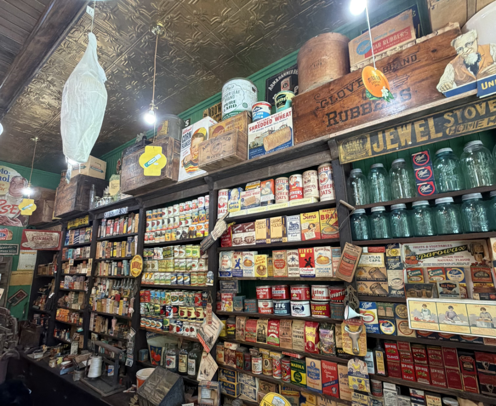 Vintage store shelves filled with various antique tins and boxes.