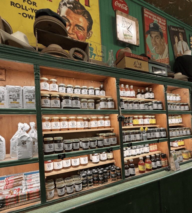 Vintage store display with shelves of jars and signs, including baseball-themed decor.