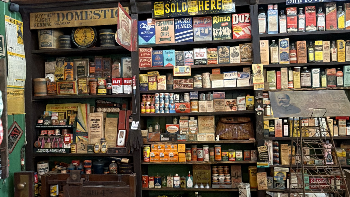 Vintage general store with shelves full of old products and baskets of laundry soap bars.
